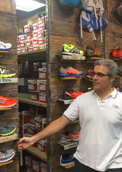 Nico Stasi demonstrates his rolling shoe display and storage shelves, built in-house with recycled materials at No Boundaries Sport.