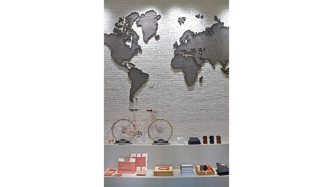 A 1930s world map sculpture hangs over a Shinola city bike