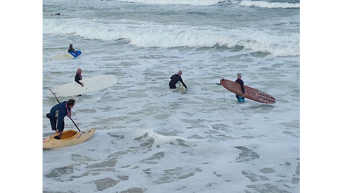 Surfers head out into blustery waters Saturday. Photo: Pat Hus