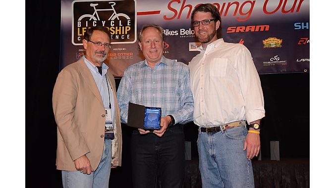 Steve Meineke (center), president of Accell North America, accepts the BRAINy Award for fastest-growing brand with annual sales over $50 million on behalf of Raleigh America from BRAIN publisher Marc Sani (left) and Leisure Trends Group president Charlie Cooper.