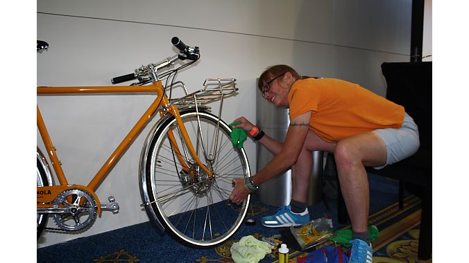 Shinola's Sky Yaeger Armor-Alls the tires on a display bike Tuesday. Photo: Steve Frothingham