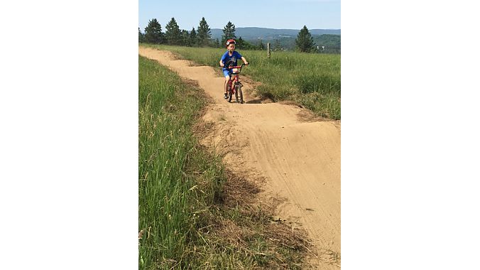 A young ripper lays down a lap in the pump track below the expo area and campground.