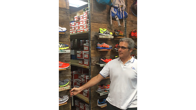 Nico Stasi demonstrates his rolling shoe display and storage shelves, built in-house with recycled materials at No Boundaries Sport.