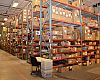 BikeWagon's warehouse is busy and huge. Workers use Raxor scooters to get around sometimes.