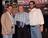 Steve Meineke (center), president of Accell North America, accepts the BRAINy award for fastest-growing brand with annual sales over $50 million on behalf of Raleigh America from BRAIN publisher Marc Sani and Leisure Trends Group president Charlie Cooper. 