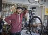 Happy guy in bike shop - stock Getty image